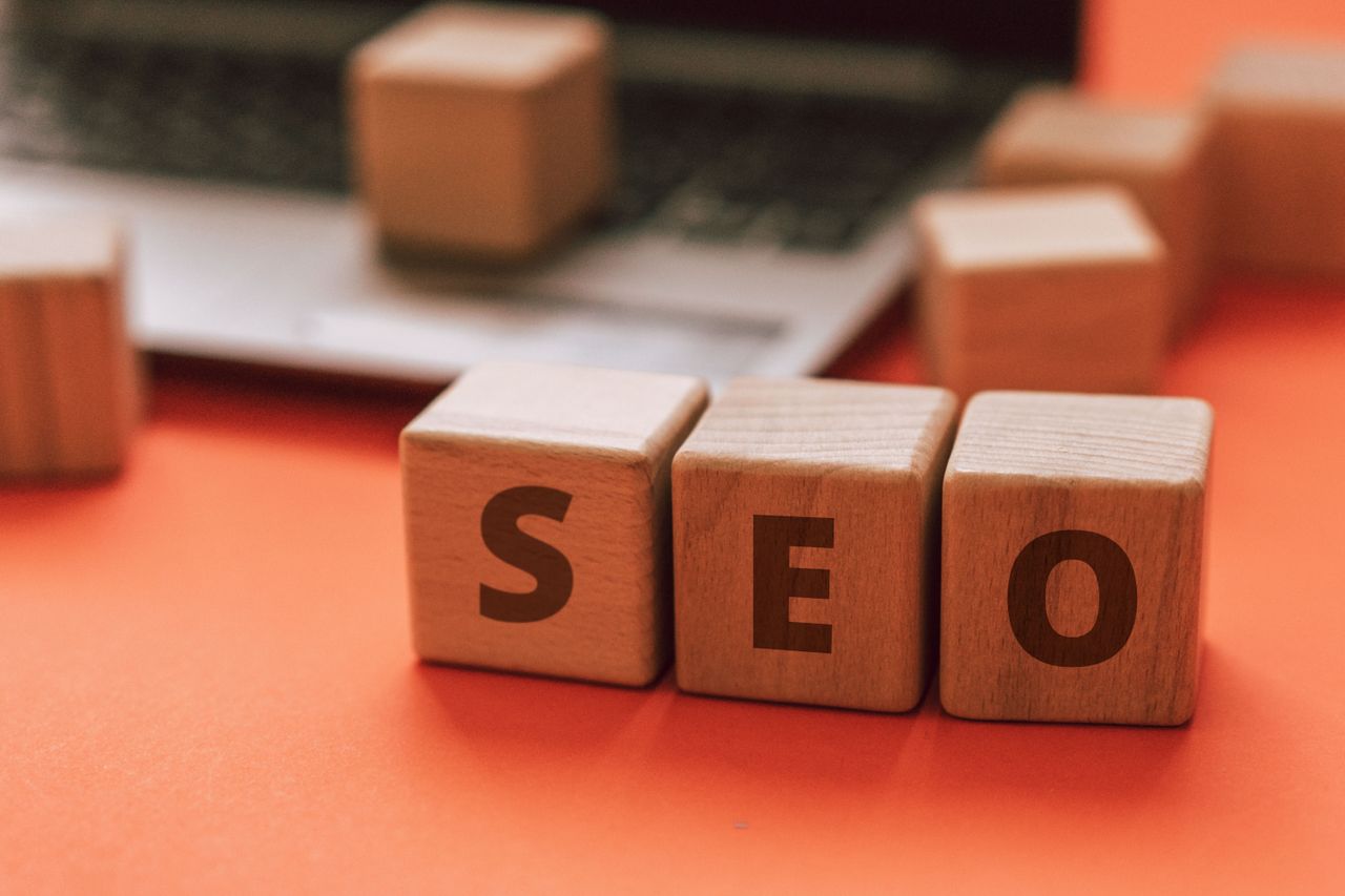 Des blocs en bois formant SEO sur un clavier d’ordinateur portable évoquent des notions de marketing digital.